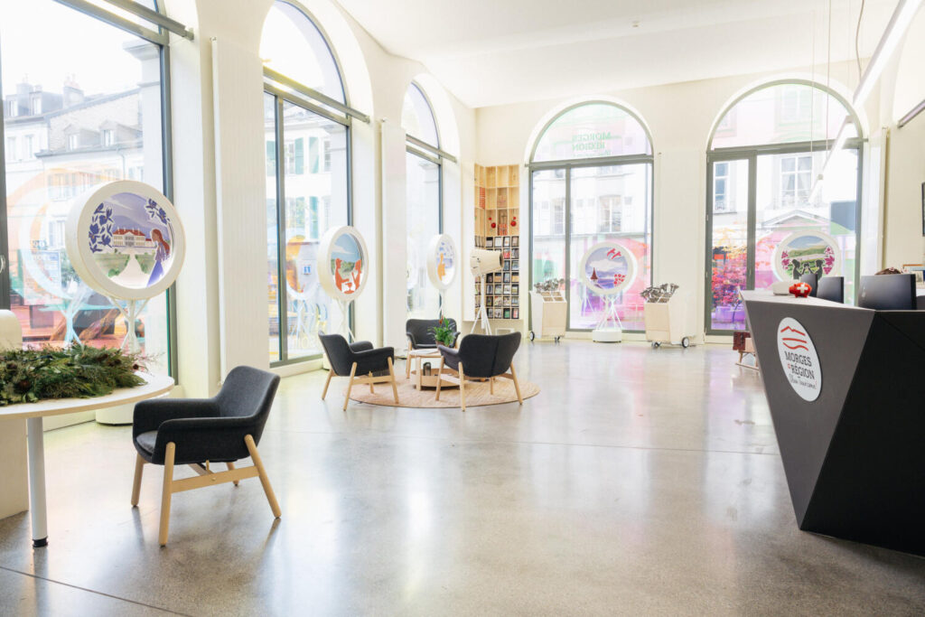 intérieur de la Maison du Tourisme, avec guichet, fauteuils, vitrines de présentation