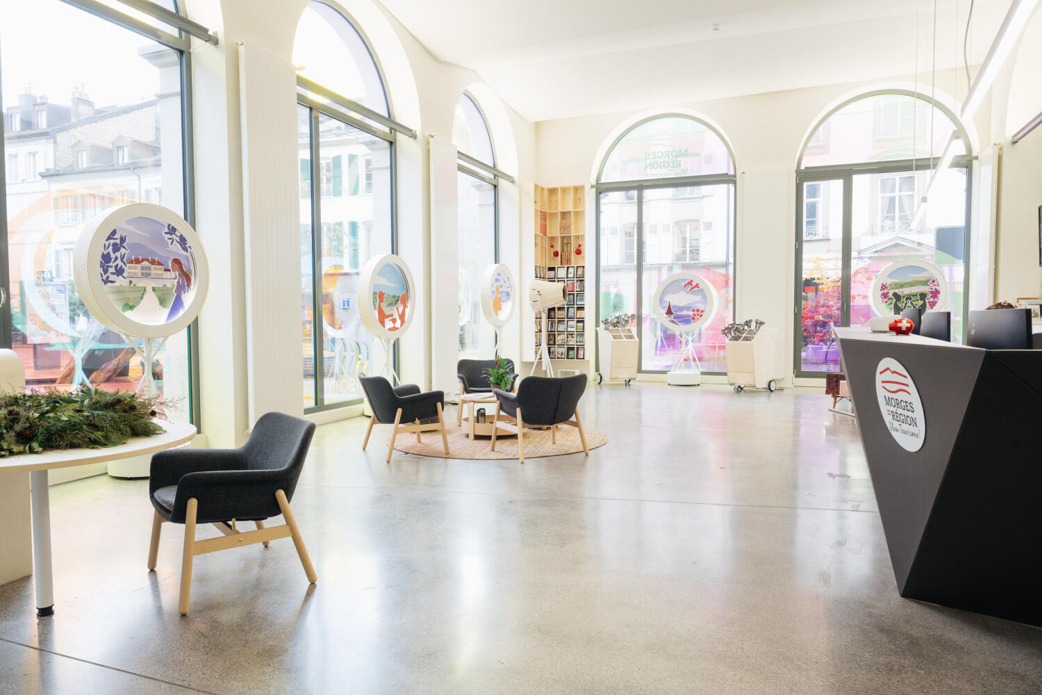 intérieur de la Maison du Tourisme, avec guichet, fauteuils, vitrines de présentation