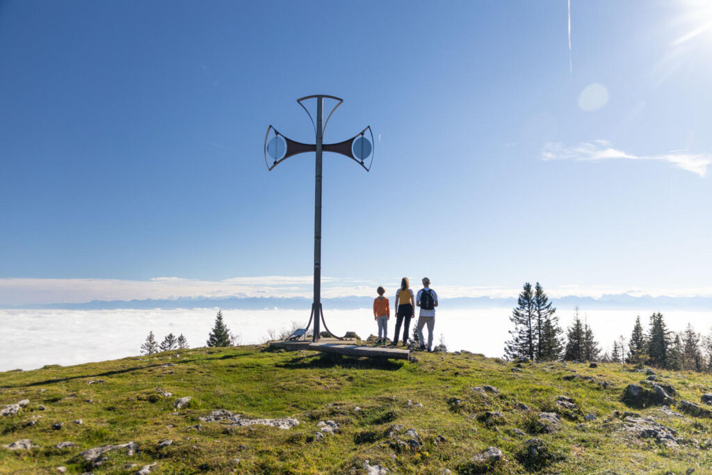 petit groupe au pied de la Croix de Châtel avec vue sur la met de nuages