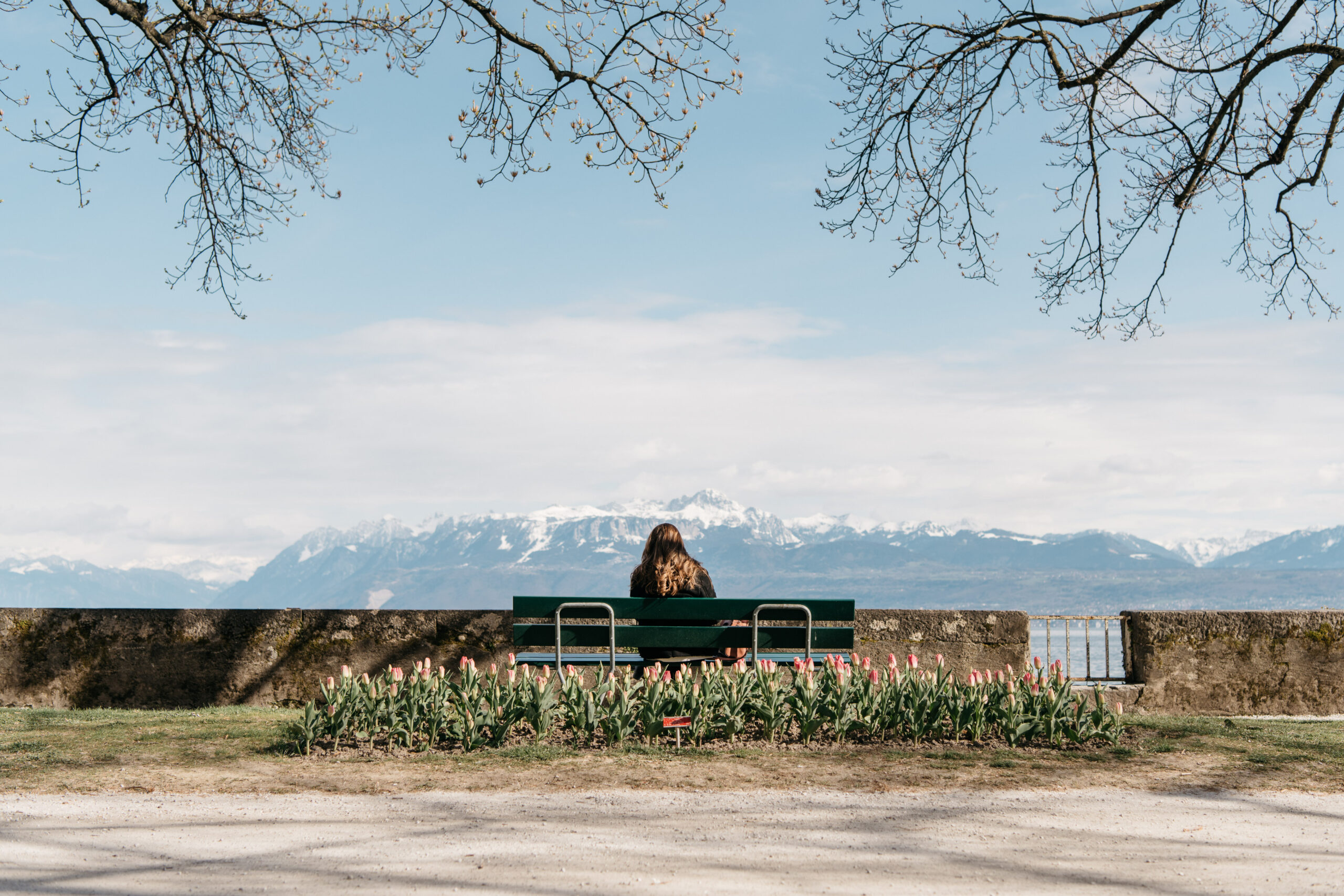 Banc dans le parc de l'Indépendance avec le lac et les montagnes en arrière-plan