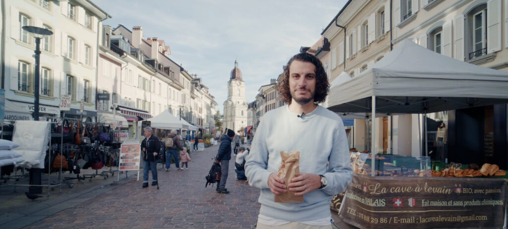 homme au marché de Morges avec le temple dans le fond
